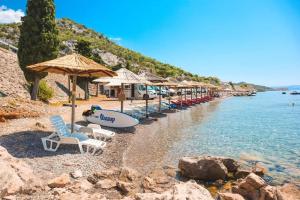 a beach with chairs and umbrellas and the water at Mobile Home Luna in Senj