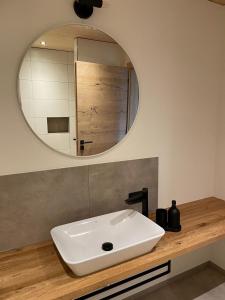 a bathroom with a white sink and a mirror at Bummler Hof Allgäu in Legau