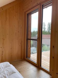 a bedroom with sliding glass doors and a balcony at Bummler Hof Allgäu in Legau