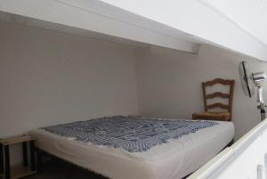 1 dormitorio con 1 cama y 1 silla en una habitación en Agréable Maison Résidence au calme - terrasse- parking privé - 6ANI84 en Le Barcarès