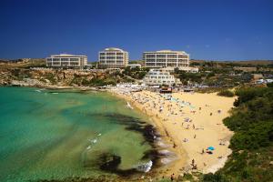 a group of people on a beach next to the ocean at A52 - Apartment with Sea and Country Views in Mellieħa