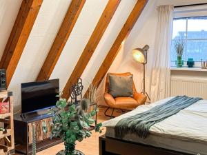 ein Schlafzimmer mit einem Bett, einem Stuhl und einem TV in der Unterkunft Achtern Diek AD2-34 in Dorum Neufeld