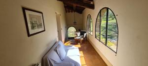 a hallway with two beds in a room with windows at Agriturismo Le Macchie in Monticchiello