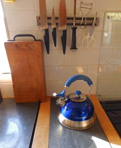 niebieski czajnik do herbaty na blacie kuchennym z nożami w obiekcie Showman's Wagon at Coed Cae w mieście Dolgellau