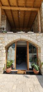 an entrance to a stone building with potted plants at Vila 369 Dhermi in Dhërmi