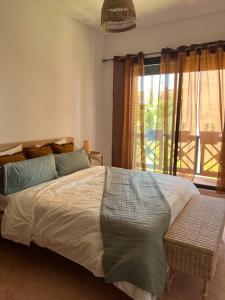 ein Schlafzimmer mit einem großen Bett und einem Fenster in der Unterkunft Résidence avec piscine in Marrakesch