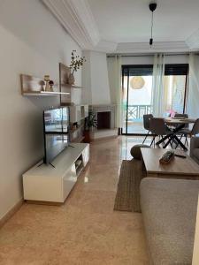ein Wohnzimmer mit einem Sofa und einem Tisch in der Unterkunft Résidence avec piscine in Marrakesch