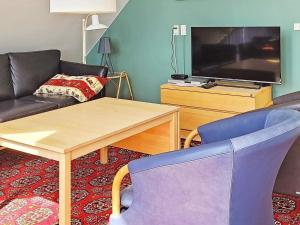 ein Wohnzimmer mit einem Sofa, einem Tisch und einem TV in der Unterkunft 6 person holiday home in R m in Rømø Kirkeby