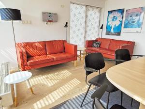 ロモ・キルケビーにある6 person holiday home in R mのリビングルーム(赤いソファ2台、テーブル付)