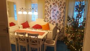 a dining room with a table and a christmas tree at Ferienhaus Segenäs Schweden in Stöllet