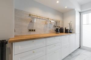 a kitchen with white cabinets and a wooden counter top at St George in Antibes