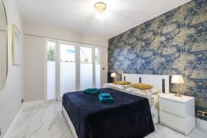 a bedroom with two beds and a blue wall at St George in Antibes