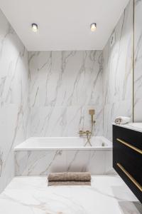 a bathroom with white marble walls and a tub at St George in Antibes