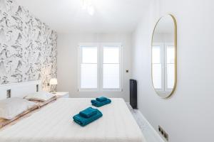a white bedroom with a bed and a mirror at St George in Antibes