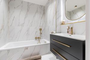 a bathroom with a sink and a tub and a mirror at St George in Antibes