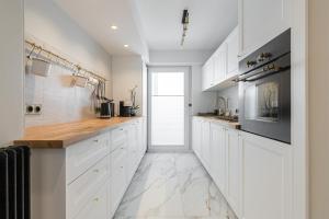 a white kitchen with white cabinets and a window at St George in Antibes