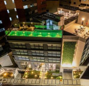 uma vista superior de um edifício com luzes verdes em Apartamento Centro Poços de Caldas em Poços de Caldas