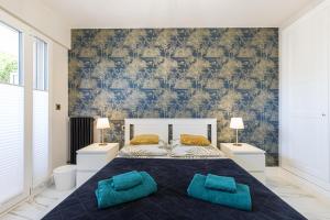 a bedroom with a large bed with two blue pillows at St George in Antibes