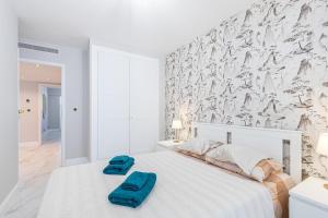 a white bedroom with a bed with two towels on it at St George in Antibes
