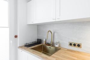 a kitchen with a stainless steel sink and white cabinets at St George in Antibes