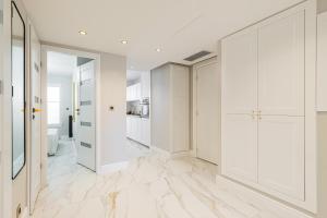 a white hallway with white cabinets and marble floors at St George in Antibes