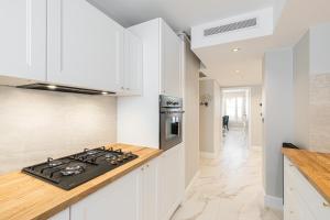a kitchen with white cabinets and a stove top oven at St George in Antibes