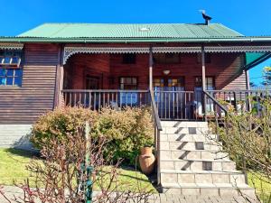 a house with a staircase in front of it at Mystic Mountain Cottage in Clarens