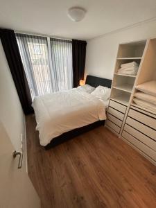 a bedroom with a bed and a large window at Noordwijk BB228 in Noordwijk