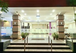 eine Lobby eines Gebäudes mit Treppen und Pflanzen in der Unterkunft Hotel 98 in Kuching