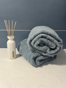 Una toalla sentada en el mostrador del baño junto a un jarrón en Blue Portisco en Marina di Portisco
