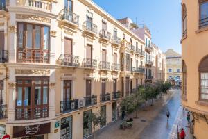 an empty street in a city with buildings at Palacete de Álamos Apartamentos in Málaga