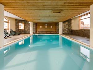 une grande piscine avec un plafond en bois dans l'établissement Spacious apartment 500 m from the slopes of Les Sybelles, à La Toussuire
