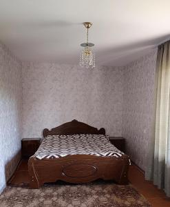 1 dormitorio con cama y lámpara de araña en Ohanatun - House with swimming pool in Byurakan, en Byurakan