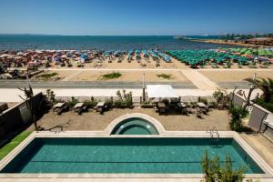 都拉斯的住宿－Hotel Vila 11，享有游泳池和带遮阳伞的海滩的景色