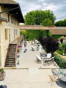 a patio with chairs and tables and a building at Le Domaine in La Chapelle-de-Guinchay