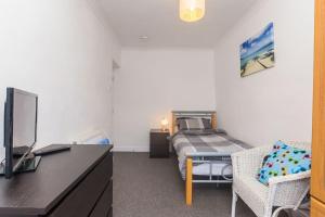 a bedroom with a bed and a desk with a tv at Ger y Bae sleeps 10 in Cemaes Bay