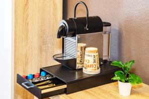 a coffee maker on a black stand on a desk at Hotel Fürst Garden in Dortmund