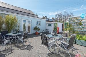a patio with tables and chairs and a building at Ger y Bae sleeps 10 in Cemaes Bay