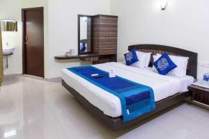 a bedroom with a large bed with blue and white pillows at AN STAYS Chennai Airport in Chennai