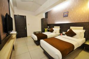 a hotel room with two beds and a flat screen tv at AN STAYS Chennai Airport in Chennai