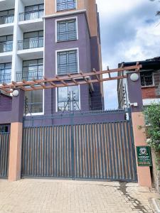 a gate in front of a house with a building at Egoli Premiere Serviced Apartments by Nest & Nomad in Nairobi