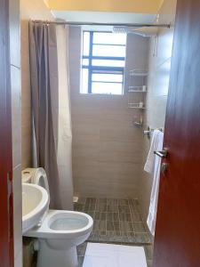 a bathroom with a toilet and a sink at Egoli Premiere Serviced Apartments by Nest & Nomad in Nairobi