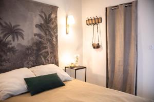 een slaapkamer met een bed met een groen kussen erop bij Rare gem 2 steps from the heart of Bordeaux in Bordeaux