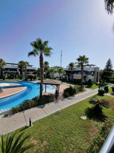 a view of a swimming pool with palm trees at The Valley 2 bedroom Apartment in Side
