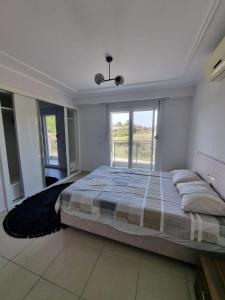 a bedroom with a bed and a large window at The Valley 2 bedroom Apartment in Side