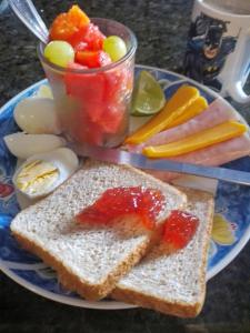 a plate of food with toast and a bowl of fruit at Tribe Beachville in El Cuyo