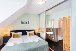 a bedroom with a large white bed and a sink at Hotel Fürst Garden in Dortmund
