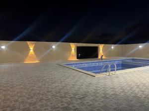 Cette chambre dispose d'une piscine avec une télévision et des lumières. dans l'établissement Gernatah Farm مزرعة غرناطه, à Ajloun