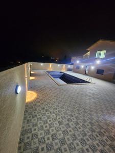 a patio at night with a pool and a building at Gernatah Farm مزرعة غرناطه in Ajloun