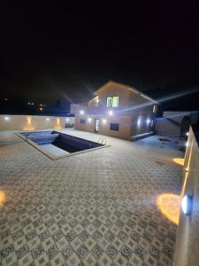 una casa con una piscina delante de ella por la noche en Gernatah Farm مزرعة غرناطه, en Ajloun